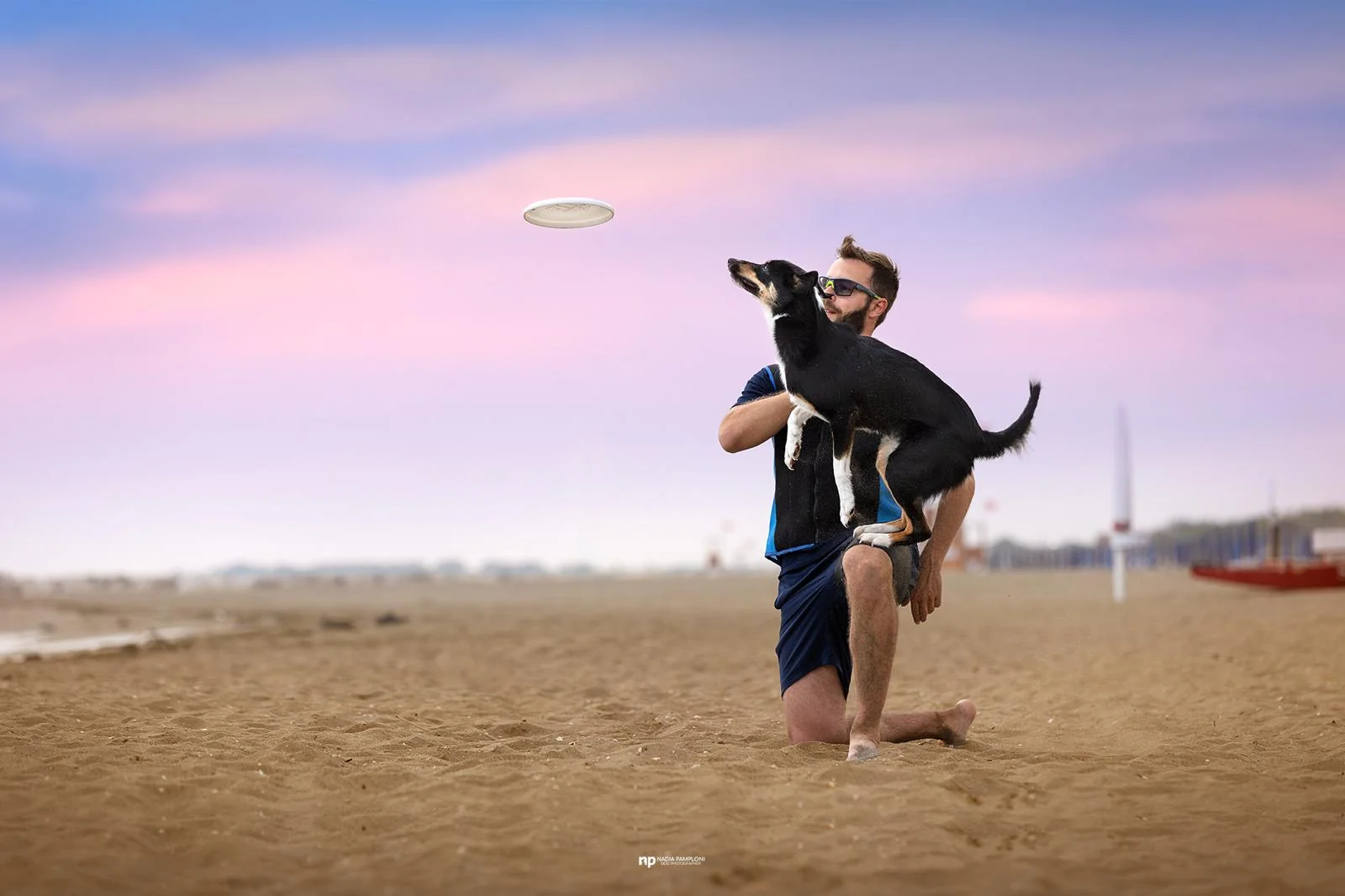 Persona seduta accanto al cane al tramonto